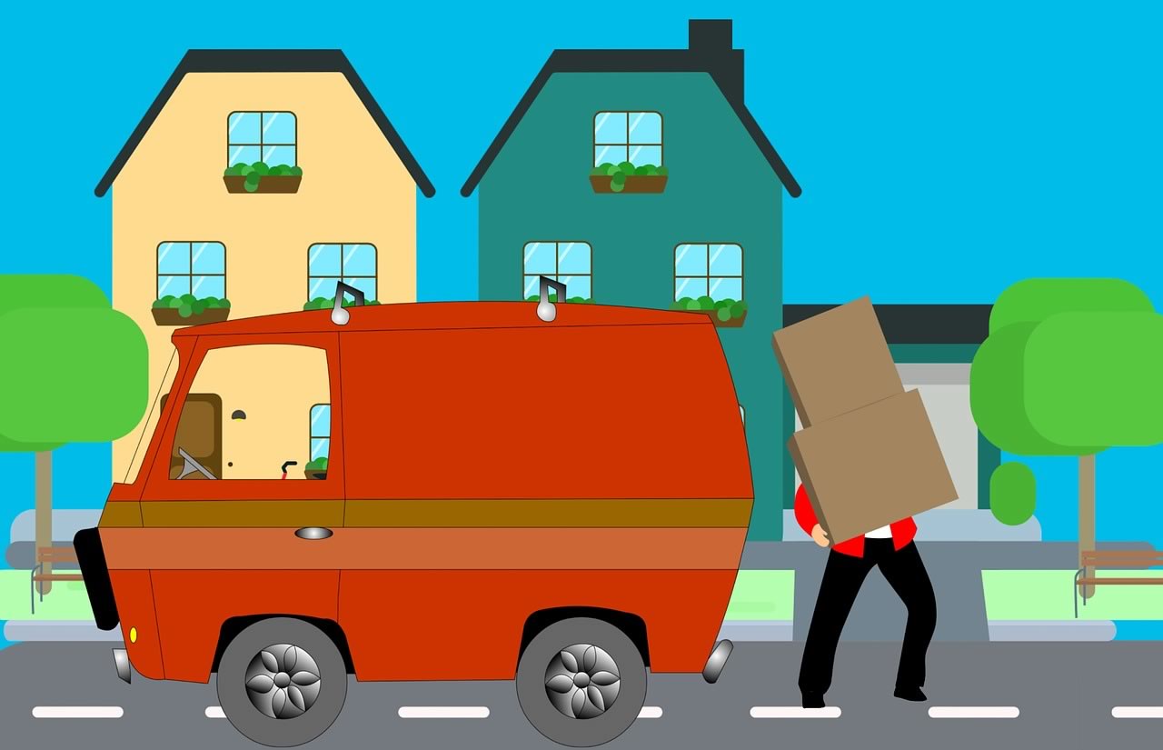 déménageur avec cartons devant un camion rouge